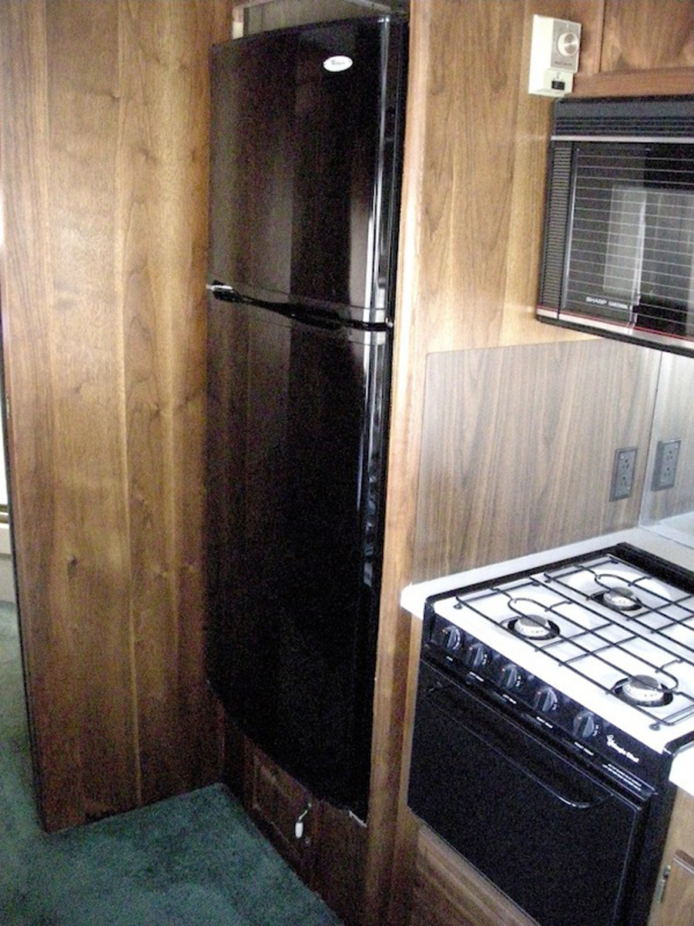 A kitchen with stainless steel appliances and wooden cabinets

Description automatically generated