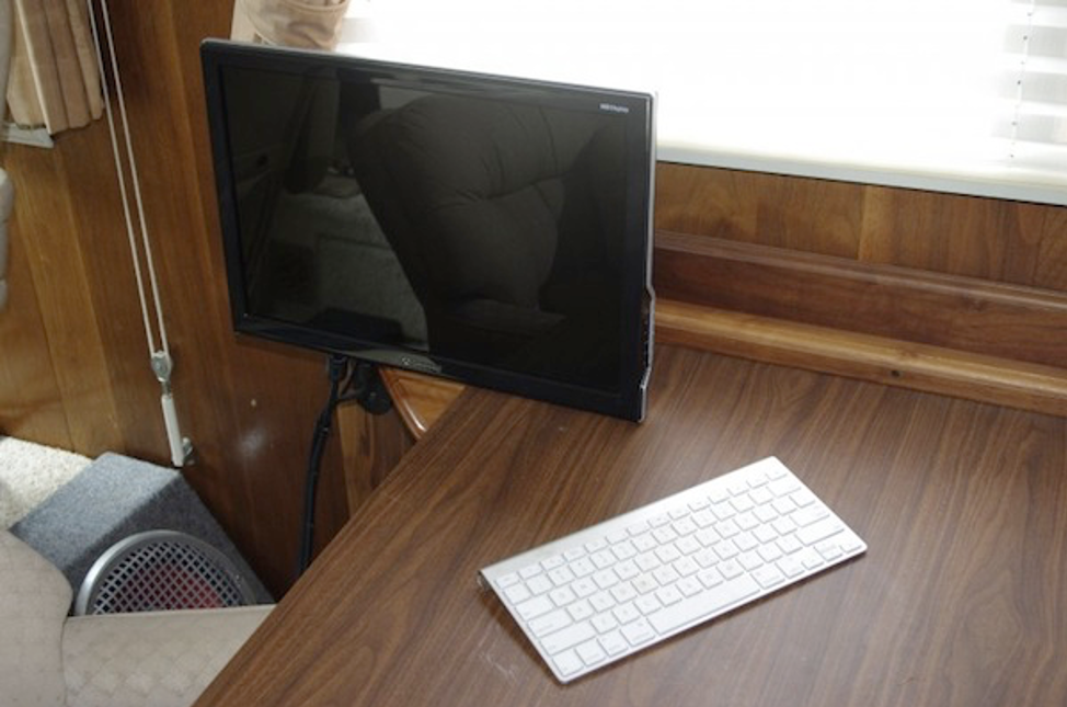 A desk with a computer on a table

Description automatically generated